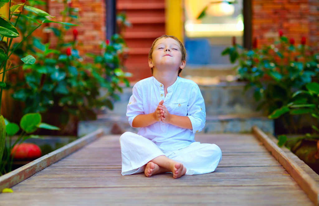 cute boy trying to find inner balance in self-care meditation